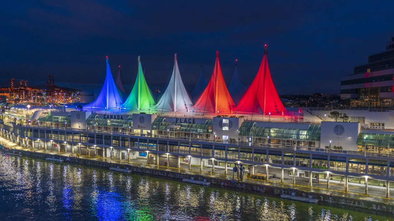 Photo of Canada Place's sails illuminated in multiple colours